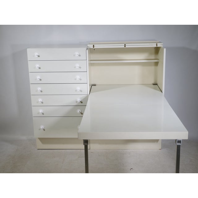 Highboard/secretary desk by Interlübke with a fold-out writing surface and a clean, minimalist design. Ample storage space...