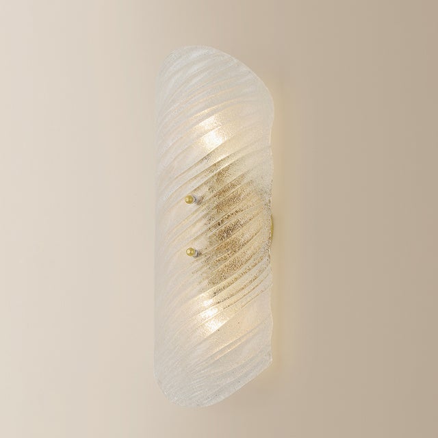 The highly textural Shelley sconce recalls the movement of flowing water. A rippled Piastre glass shade reinterprets a...