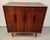 Striking mid-century modern cabinet crafted in richly grained wood, featuring clean Scandinavian-inspired lines and...