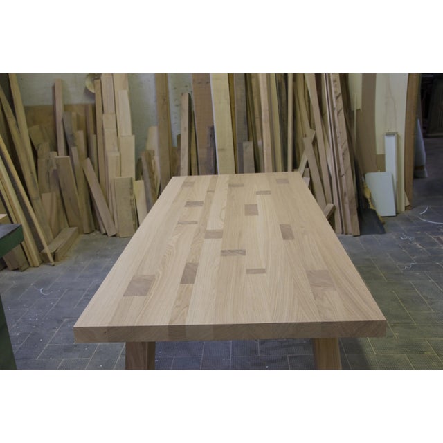 "A fixed table of handcrafted manufacture, made entirely of top-quality solid oak planks. The sloping legs-which in the...
