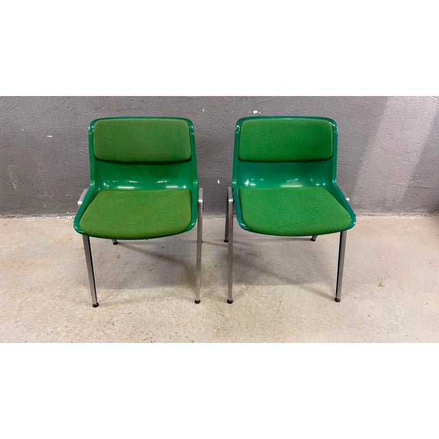 A striking pair of Mid-Century Modern conference chairs featuring vibrant green molded shells with matching upholstered...