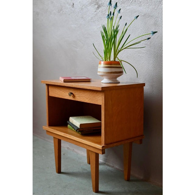 with its slender legs and warm wood tone, this vintage bedside table is elegant and full of charm. Its original knob...