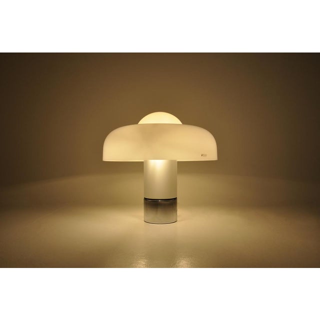 White plastic and metal lamp. Double switch to choose whether to turn on part or all of the lamp. Stamped Harvey Guzzini...