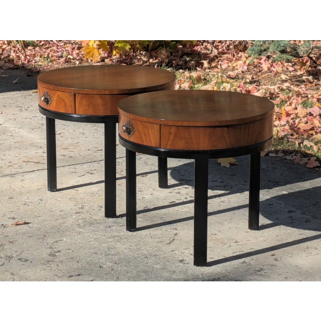 Posted is a stunning rare pair of Walnut and black painted three leg round tables. This set was made by the Fine Arts...