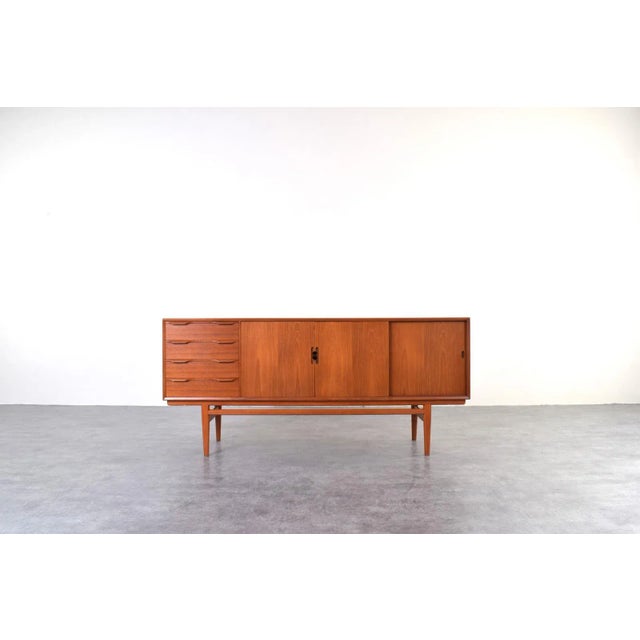 This teak sideboard was manufactured in Denmark in the 1960s. It has been professionally and carefully restored by...
