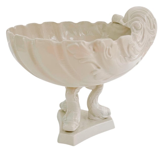 A beautiful mid-century Italian whiteware pedestal centerpiece featuring a large intricate shell bowl sitting atop three...