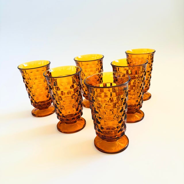 A set of 6 tall vintage footed glasses with a cubist design in amber glass. Made in the Whitehall pattern by Colony....