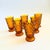 A set of 6 tall vintage footed glasses with a cubist design in amber glass. Made in the Whitehall pattern by Colony....
