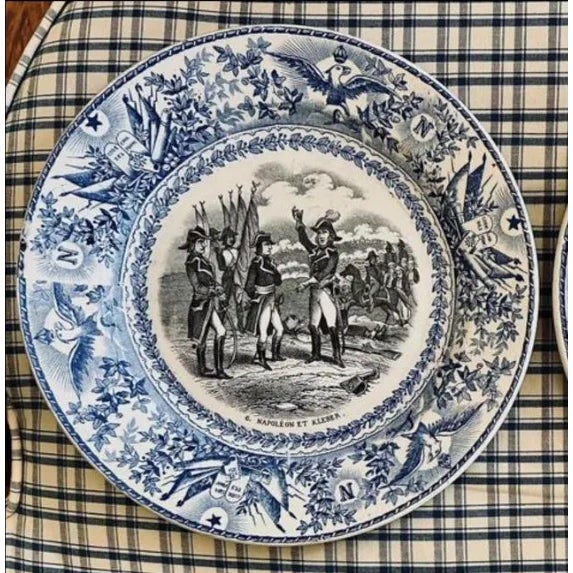 Pair of blue, black, white transferware plates, 8” diameter, depicting Napoleonic military scenes.