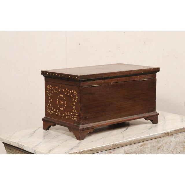 A Kashmiri wooden tabletop keepsake box with decorative floral inlay. This vintage wooden box from Kashmir, India is...