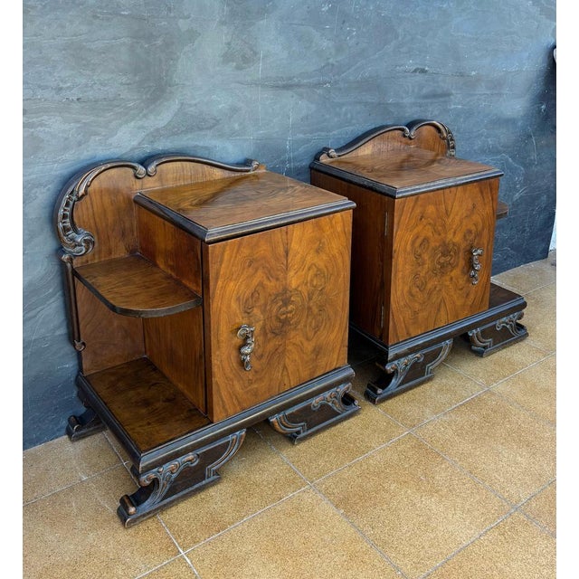 Pair of European Art Deco Nightstands, circa 1930s. Crafted in walnut veneer with striking symmetrical grain patterns,...