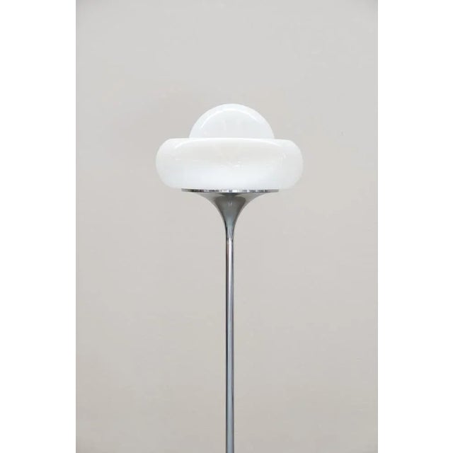Iconic rare-form Italian floor lamp designed for Guzzini in the 1960s. Round chromed metal base with cast iron...