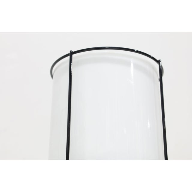 Illuminate your space with this 1970s pair of Artemide table lamps, featuring enameled metal frames and elegant Lucite...