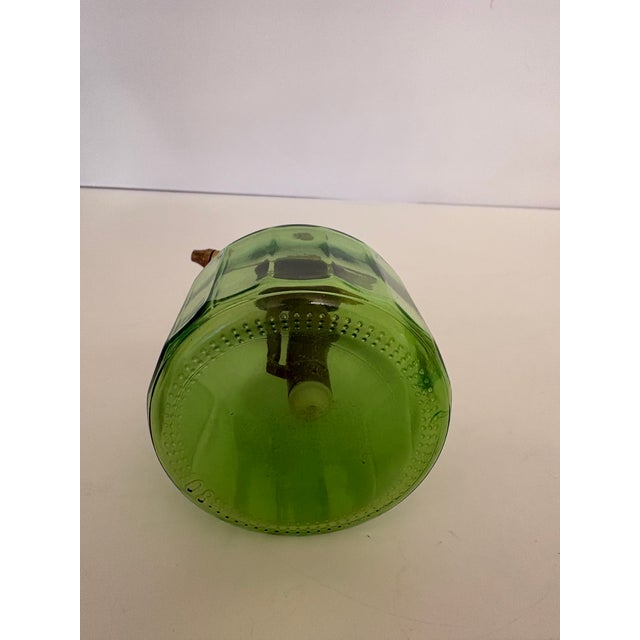 This vintage atomizer made of green glass stands at 6 inches tall and has a brass handle which spritzes water onto the...