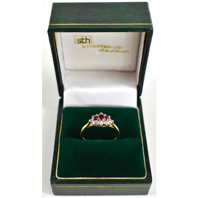 A vintage 18ct gold ruby & diamond cluster ring. The design centres three vivid round-cut rubies totalling 0.35cts, each...