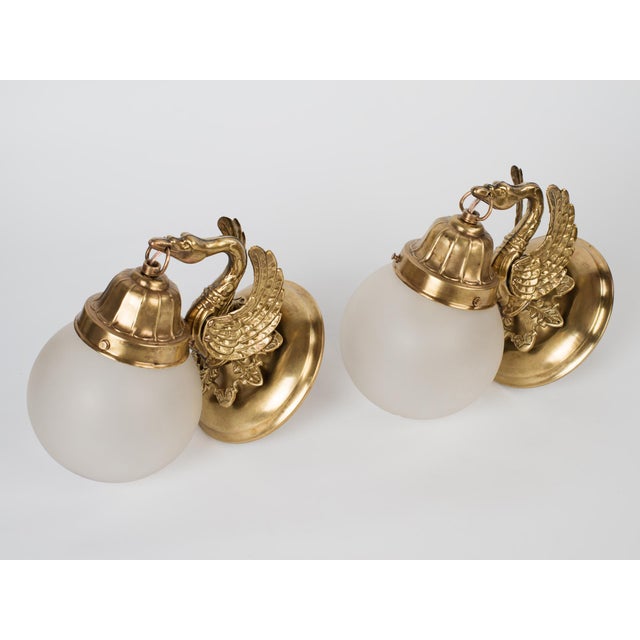 Spectacular Pair of 1950s Spanish Empire Style Hand-Chased Brass 1-Light Wall Sconces. Outfitted with original matching...