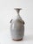 This vintage studio pottery vase features a rounded, sculptural body with a narrow flared neck, showcasing refined...