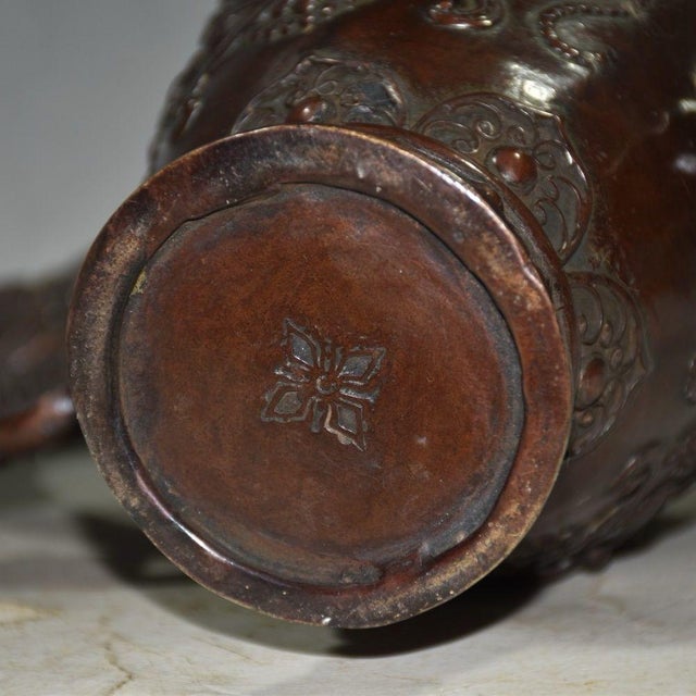 This impressive vessel, traditionally used for serving wine or tea, is heavily decorated with intricate high-relief...