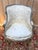 A louis xvi period wingback armchair in carved wood, lacquered gray and painted, with a characteristic wraparound frame....