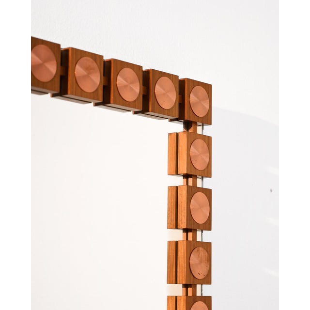 Swedish teak wall mirror with geometric elements and circular copper inserts. Made by Glas & Trä Hovmantorp, 1970s....
