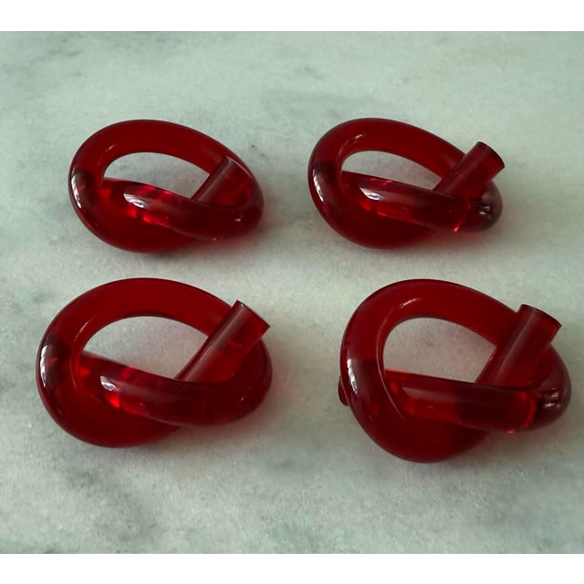 Set of 4 mid century red lucite acrylic napkin rings in the shape of a pretzel or knot in the style of Dorothy Thorpe.