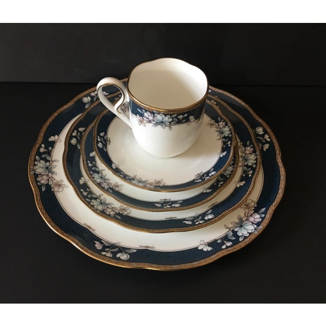Noritake Sandhurst 5 Piece Place Setting Fine China Features pale pastel blue, lavender & tan floral over a darker blue...