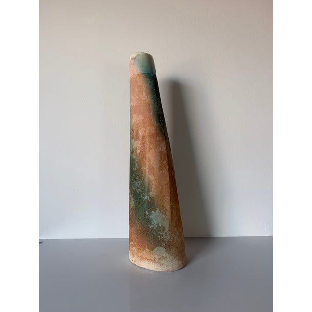 Striking 1980s studio pottery vase by Tony Evans, featuring a tall, slender tapered form with an organic Raku-style glazed...