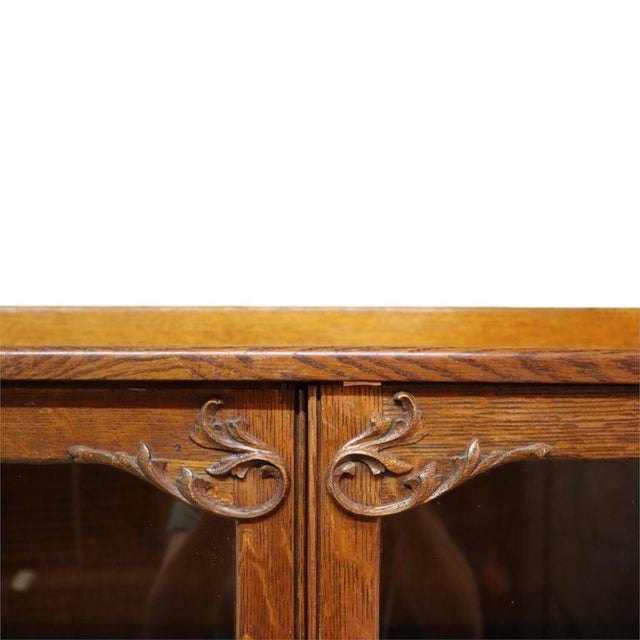 This oversized antique bookcase was crafted by Hersee & Co., featuring a robust oak construction. The piece is designed...