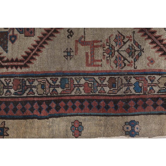 An early 20th century antique Persian camel hair rug runners, the striated camel field with abstract figural and floral...