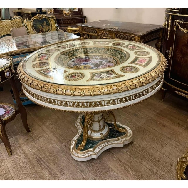 Create an extraordinary dining space with this grand French-inspired round dining table, featuring an elegant white...