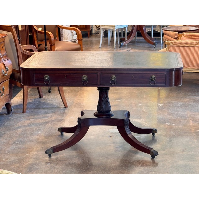 A handsome Regency-period English library table crowned with a gilt-tooled leather writing surface in warm, mellowed...