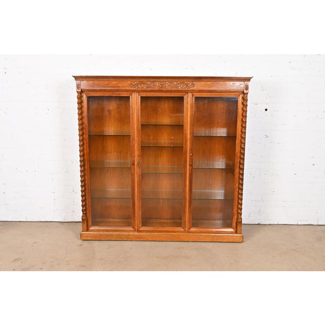 A beautiful antique Victorian or Renaissance Revival lighted triple bookcase or display cabinet In the manner of R. J....