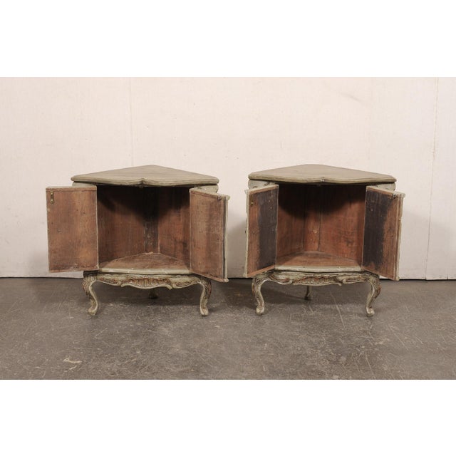 A near pair of Italian table-height painted corner cabinets from the Early 20th century. These antique cabinets from Italy...