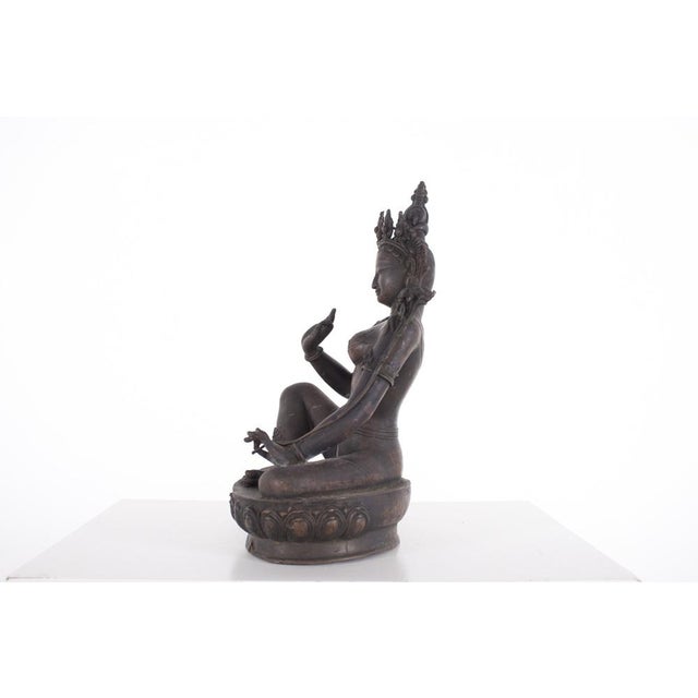 Green copper alloy sculpture depicting a Nepalese female deity, dating from the 19th century. H 32 cm x W 22 cm x D 15 cm....