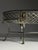 Oval vintage coffee table. Silver-colored metal base with a beveled glass top. Empire / Regency style. Characteristic...