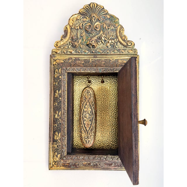 This wall cabinet with beveled mirror and accompanying brush is executed in the victorian style. the richly ornamented...