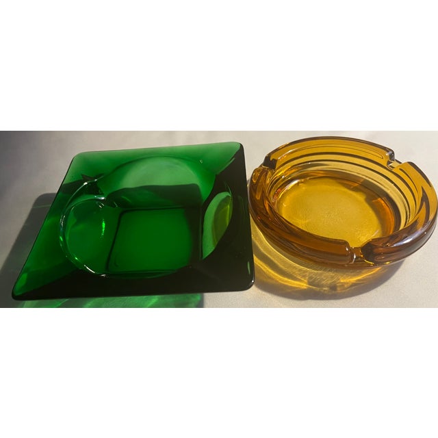This is a set of two mid century modern ashtrays. The square emerald/forest green is Anchor Hocking manufactured between...