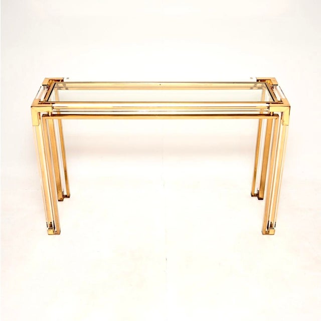 A stunning vintage Italian Lucite and brass console table, dating from the 1970’s. It has a very decorative style and is...