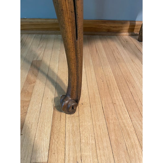 Simply elegant and functional Baker Furniture walnut burl side table. Features a beautifully scalloped apron with cabriole...