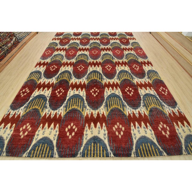 A modern Ikat rug hand-knotted with fine wool on a cotton foundation. This rug features botanical motifs set against a...