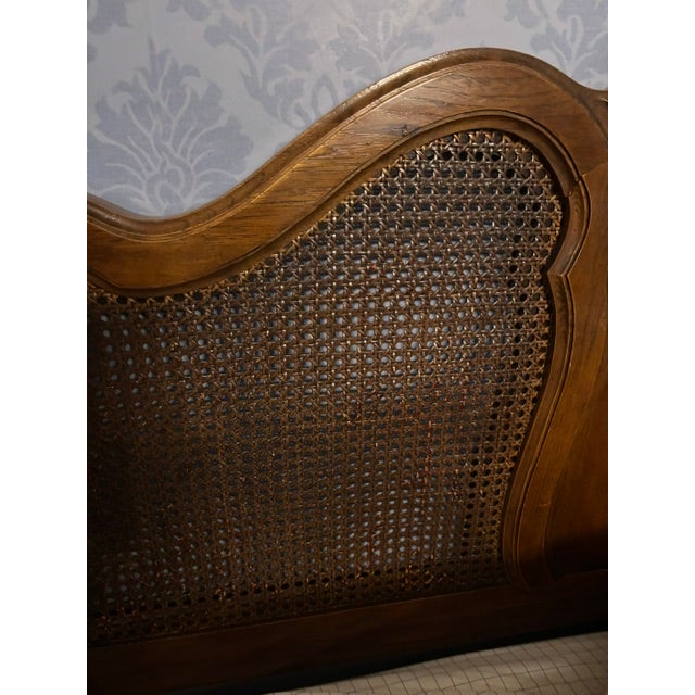 An elegant French Provincial style headboard featuring a serpentine shaped crest rail accented by a carved central shell...