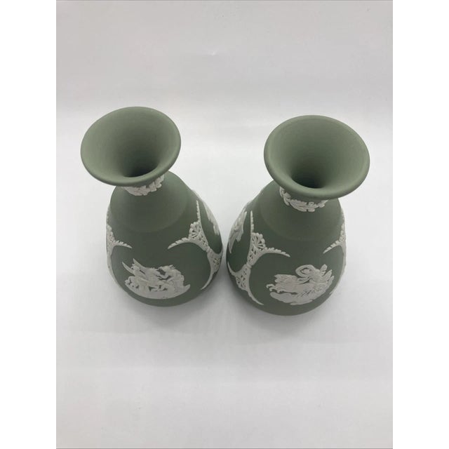 Elegant pair of classic sage green Jasperware vases by the esteemed English maker Wedgwood. Each vase measures...