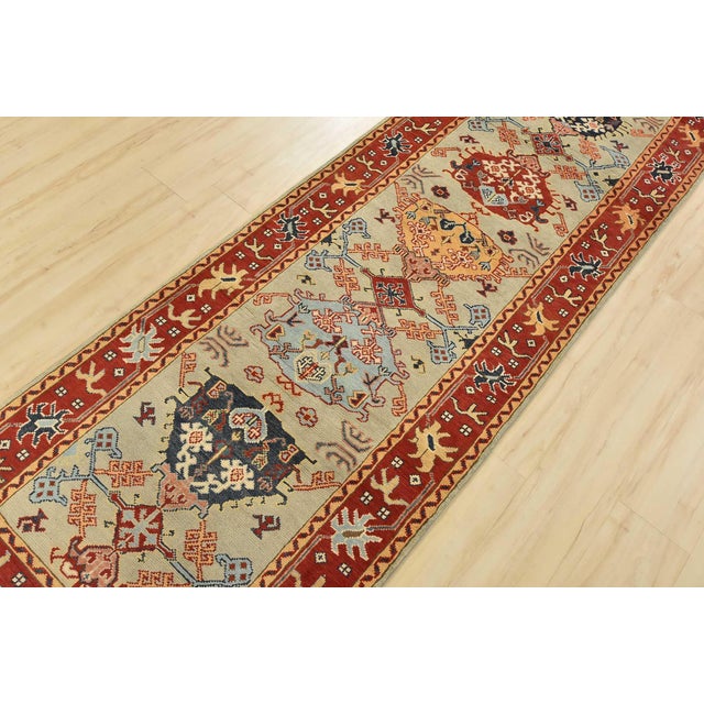 A traditional tribal Caucasian Kazak runner hand-knotted with an all-wool pile on a cotton foundation. This oriental rug...