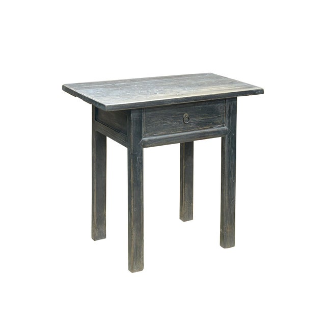 Crafted from sturdy timber, the table features a rectangular top with a slightly uneven surface, revealing the natural...