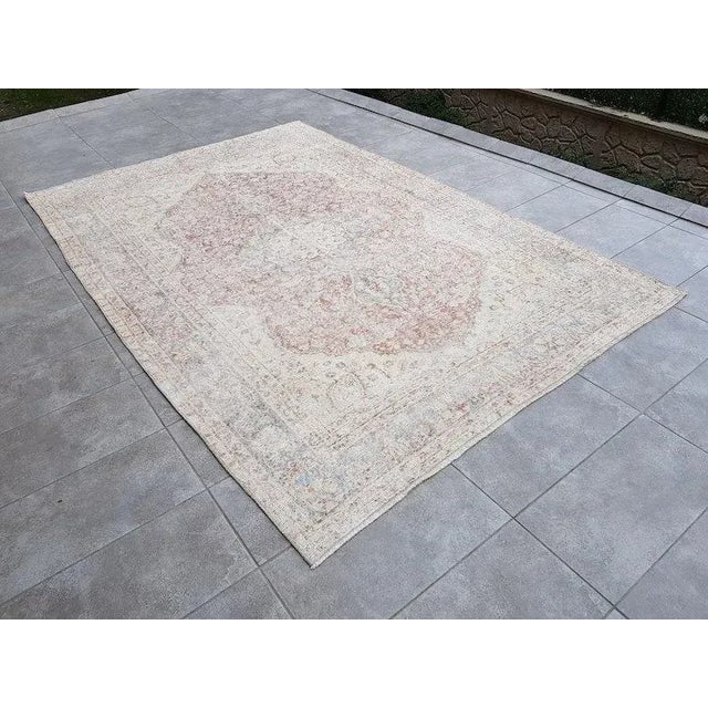 This is a vintage Turkish Oushak rug from the 1960s. The piece was hand-knotted