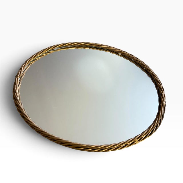 Elegant vintage oval mirrored vanity tray featuring a beautifully detailed braided rope-style metal border in a warm...