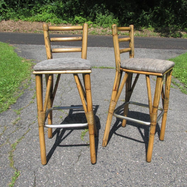 Set of three vintage 1950s era bamboo and rattan bar stools with distressed old paint. High quality and well constructed....