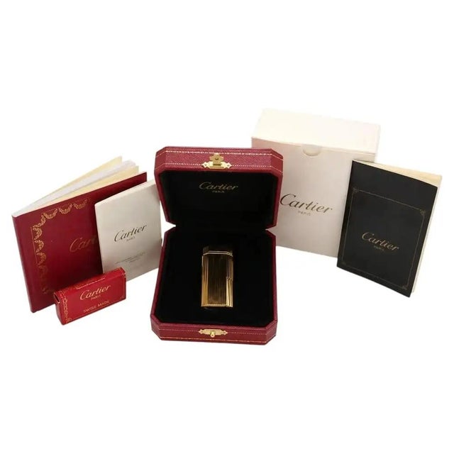 Vintage must de cartier trinity pocket lighter in 18k gold-plated metal, with a vertically ribbed body and distinctive...