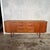 A generous 1960s teak sideboard by Austinsuite, designed by Frank Guille, with sculpted recessed handles and refined...