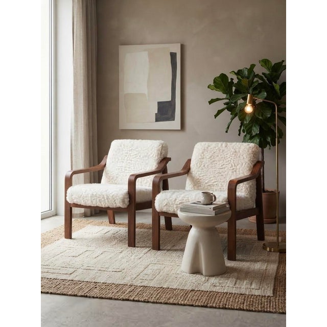 A rare and collectible matching pair of fully refurbished mid-century modern lounge armchairs designed by renowned...